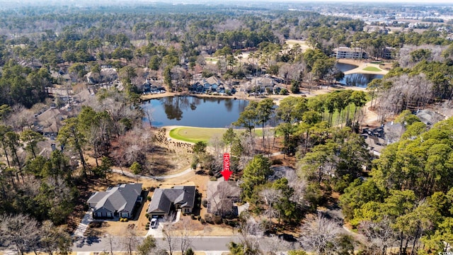 birds eye view of property with a water view and a wooded view