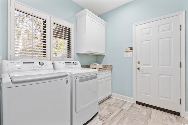 laundry area featuring cabinet space, baseboards, light wood finished floors, and independent washer and dryer