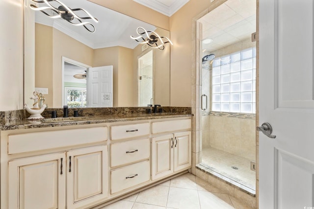 bathroom featuring a wealth of natural light, crown molding, a shower stall, and a sink