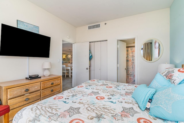 bedroom featuring visible vents, a closet, and wood finished floors