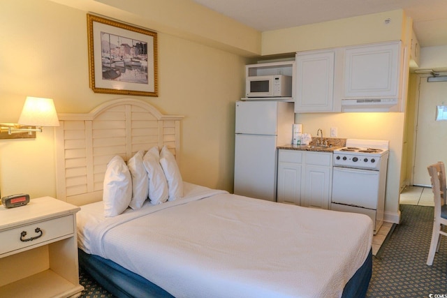 bedroom with freestanding refrigerator, a sink, and light tile patterned floors