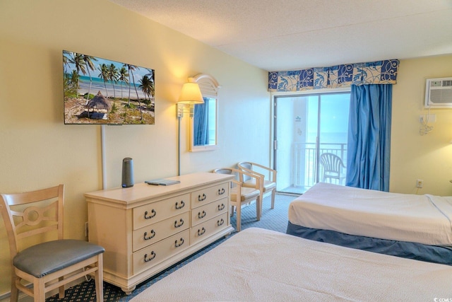 carpeted bedroom with access to exterior, a textured ceiling, and a wall mounted AC