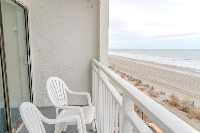 balcony featuring a water view and a view of the beach