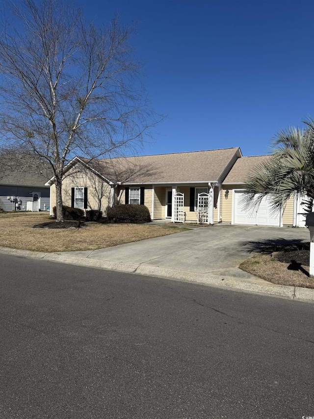 view of front of house featuring driveway, a shingled roof, and an attached garage