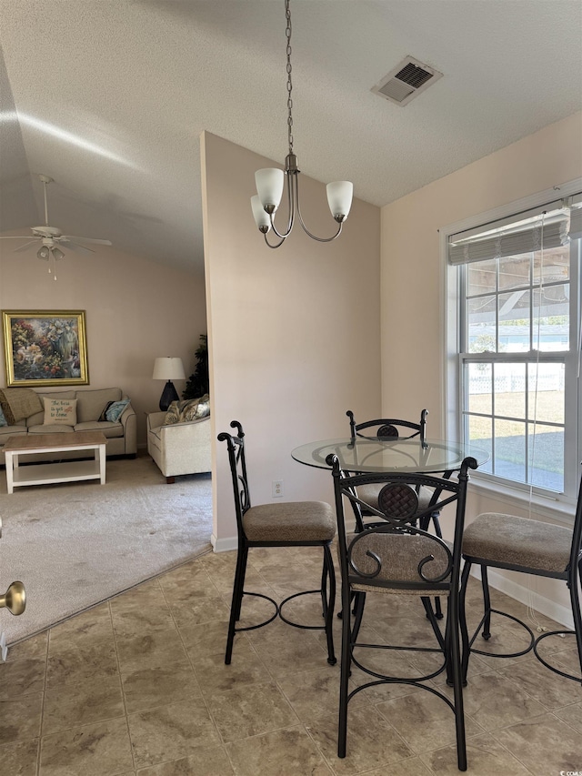 dining room featuring lofted ceiling, a textured ceiling, carpet, and visible vents