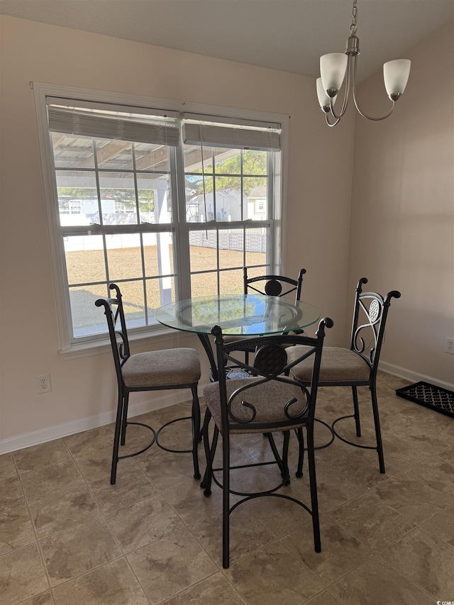 dining room featuring baseboards and an inviting chandelier