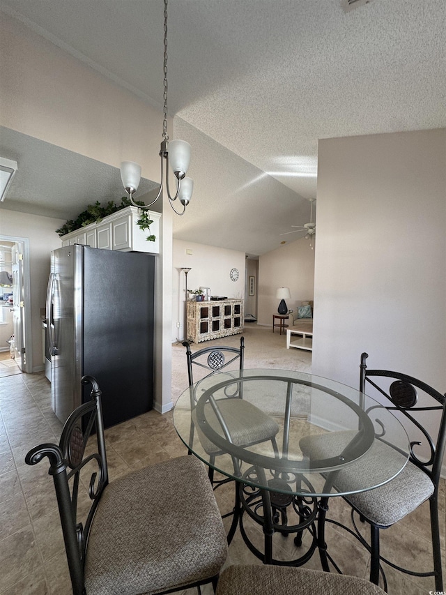 dining room featuring vaulted ceiling, a textured ceiling, and a ceiling fan