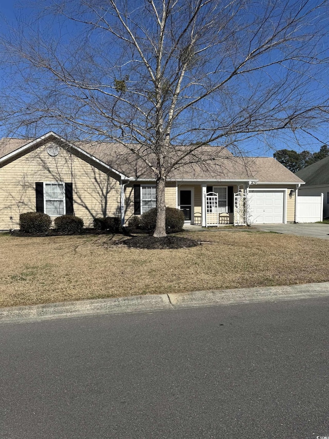 view of front of home with a garage, a front yard, covered porch, and driveway