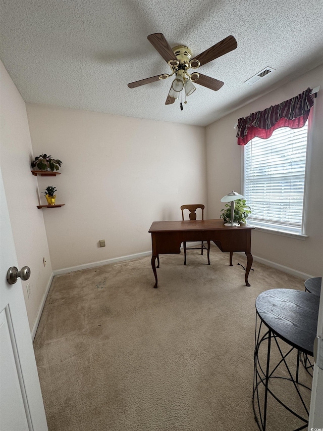 office area featuring baseboards, a textured ceiling, visible vents, and carpet flooring