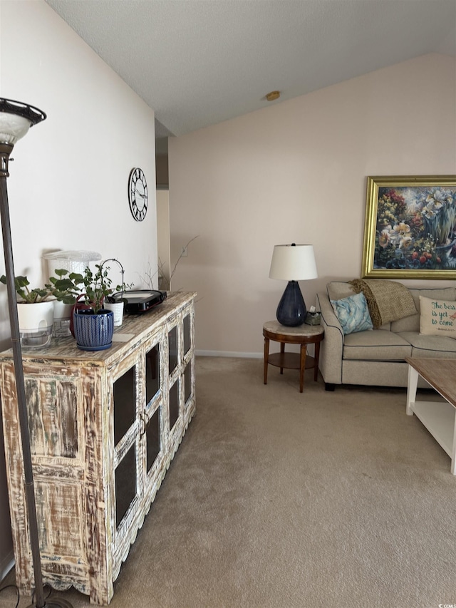 living room featuring vaulted ceiling, carpet flooring, and baseboards