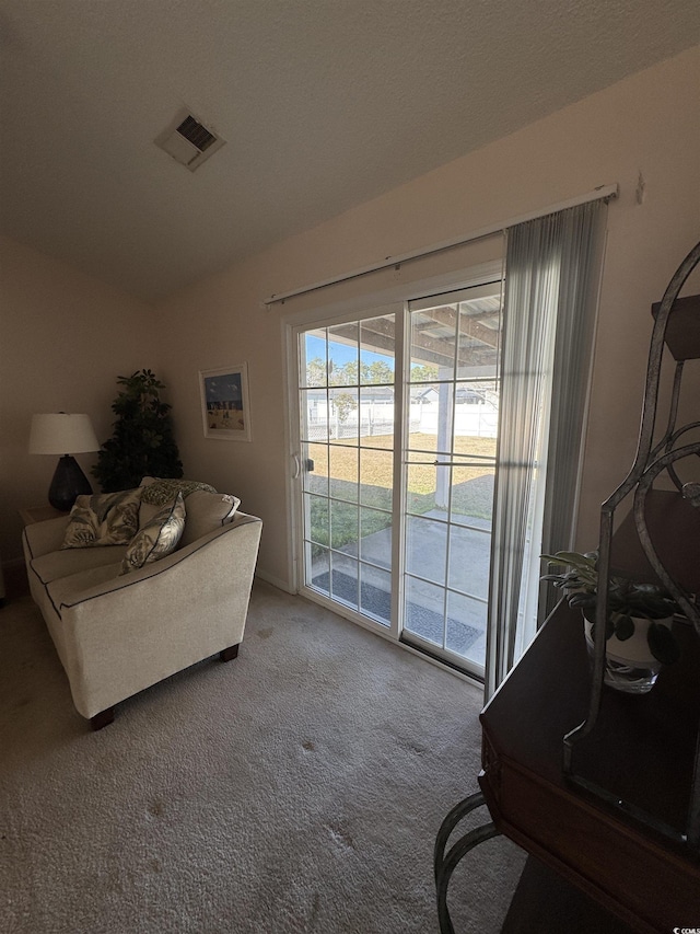 interior space with lofted ceiling, carpet, and visible vents