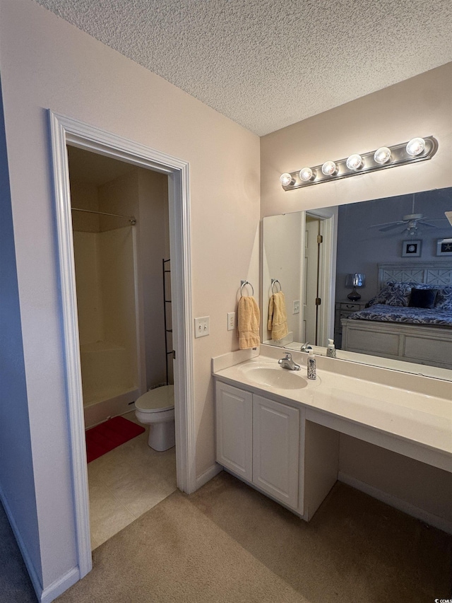 full bathroom with a textured ceiling, vanity, baseboards, a ceiling fan, and walk in shower