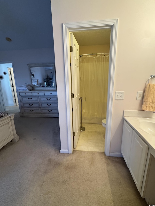 bathroom featuring toilet, a shower with shower curtain, carpet flooring, and vanity