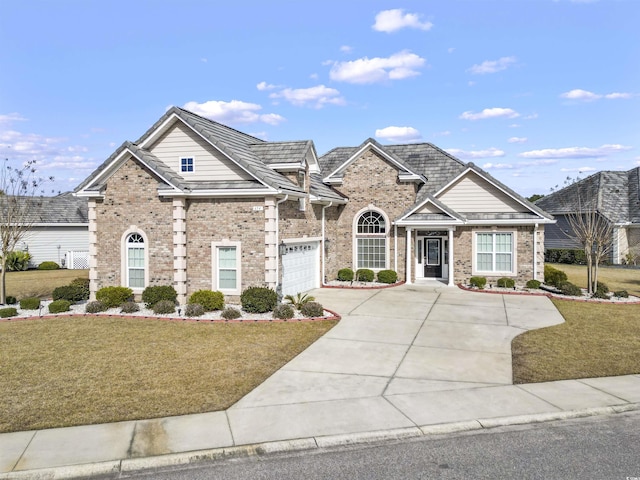 view of front of property featuring concrete driveway, brick siding, and a front yard