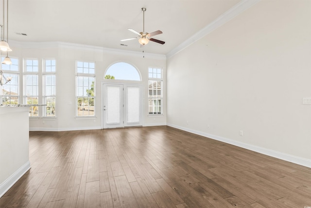 unfurnished living room featuring ceiling fan, baseboards, dark wood-type flooring, and ornamental molding