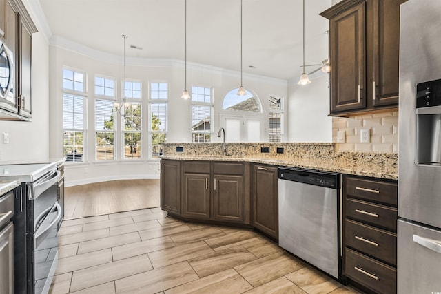 kitchen with stainless steel appliances, ornamental molding, a sink, and dark brown cabinetry