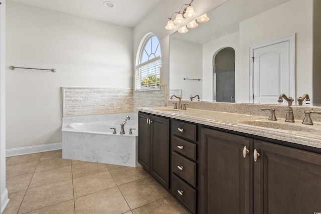 bathroom with double vanity, tile patterned flooring, a sink, and a bath