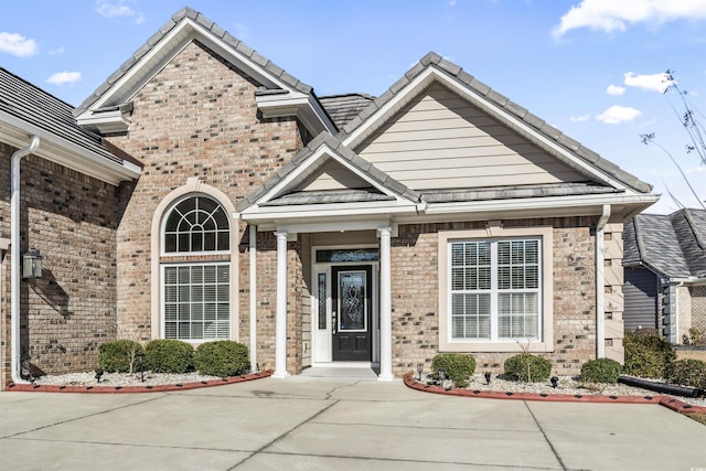 view of front of house with brick siding and a tiled roof