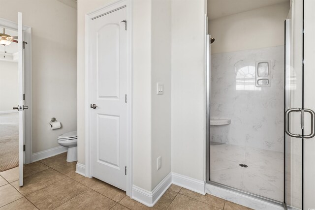 full bath with tile patterned flooring, baseboards, toilet, and a marble finish shower