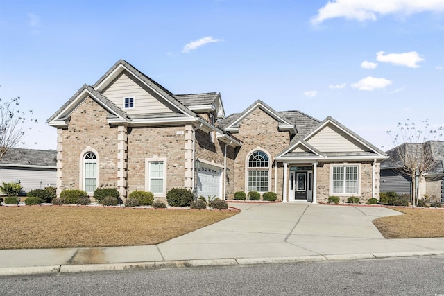 view of front of home featuring driveway, a garage, and brick siding