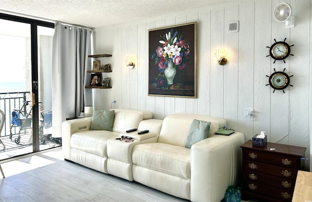 living room featuring a textured ceiling, wood finished floors, and expansive windows