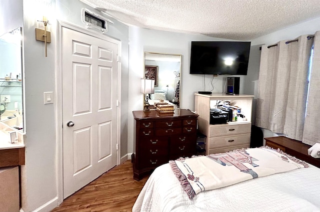 bedroom with wood finished floors and a textured ceiling