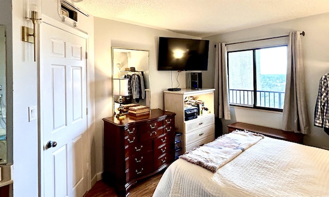 bedroom featuring a textured ceiling and dark wood-style flooring