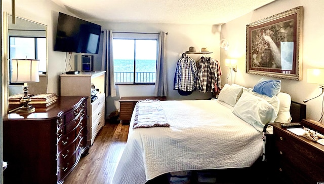 bedroom featuring dark wood finished floors and a textured ceiling