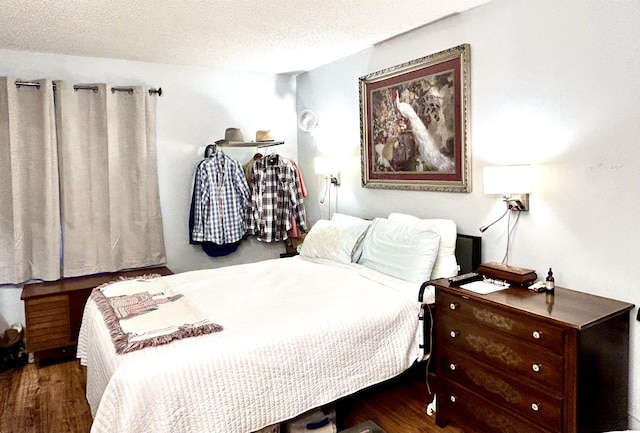 bedroom featuring wood finished floors and a textured ceiling