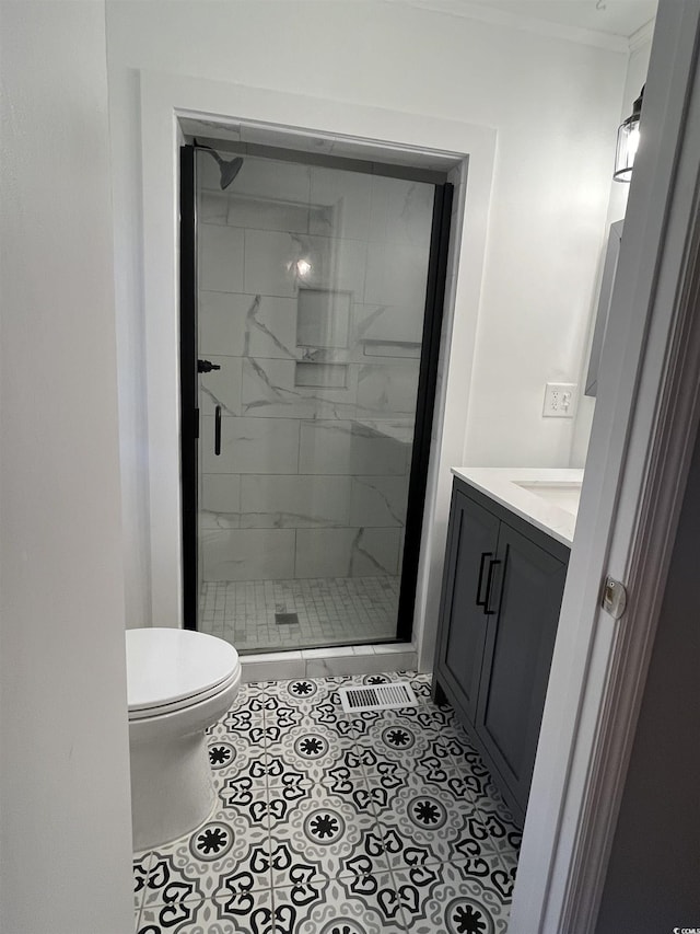 full bathroom featuring a stall shower, toilet, ornamental molding, tile patterned flooring, and vanity