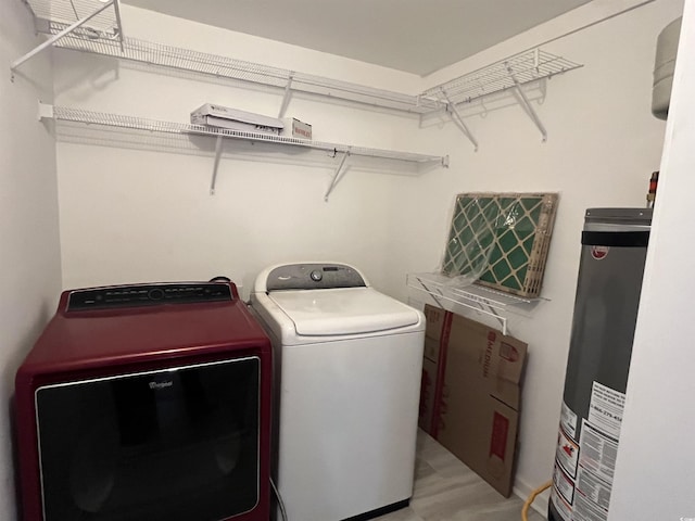 clothes washing area with gas water heater, washing machine and clothes dryer, and laundry area