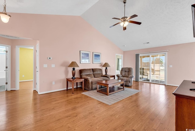 living room with visible vents, light wood-style flooring, ceiling fan, high vaulted ceiling, and baseboards