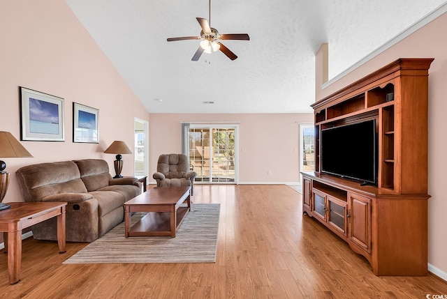 living room featuring a textured ceiling, ceiling fan, high vaulted ceiling, baseboards, and light wood-style floors