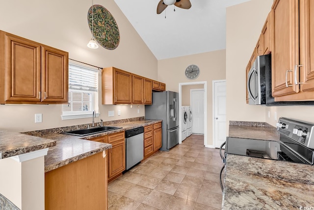 kitchen featuring stainless steel appliances, a peninsula, a sink, brown cabinets, and washer and clothes dryer