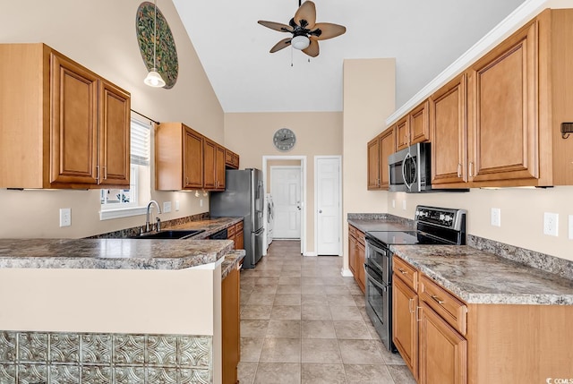 kitchen featuring brown cabinets, a peninsula, stainless steel appliances, and a sink