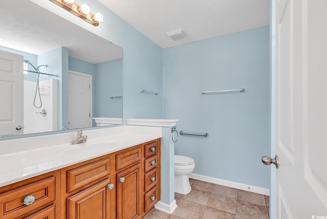 bathroom featuring baseboards, toilet, tile patterned floors, walk in shower, and vanity