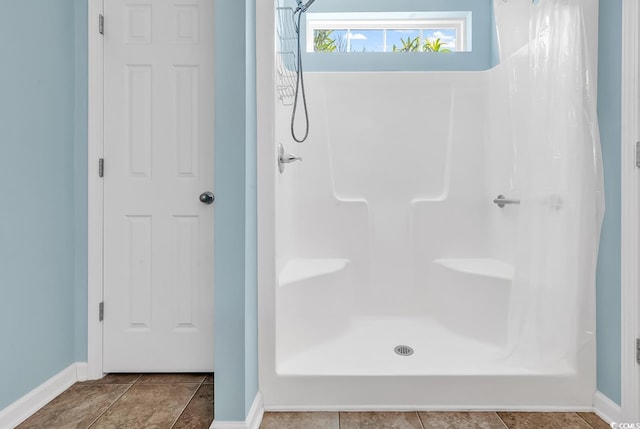 full bathroom with baseboards, a shower with shower curtain, and tile patterned floors