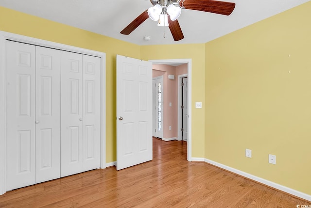 unfurnished bedroom with baseboards, a closet, a ceiling fan, and light wood-style floors