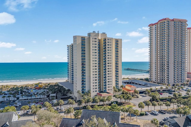 drone / aerial view with a city view, a water view, and a beach view