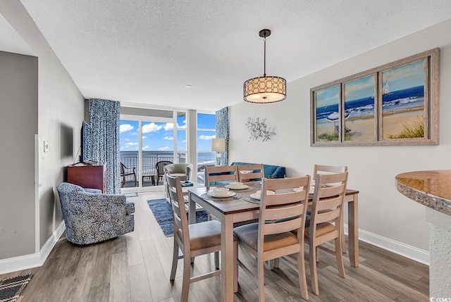 dining room with floor to ceiling windows, visible vents, a textured ceiling, wood finished floors, and baseboards