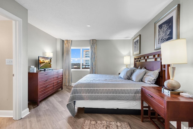 bedroom with light wood finished floors and baseboards