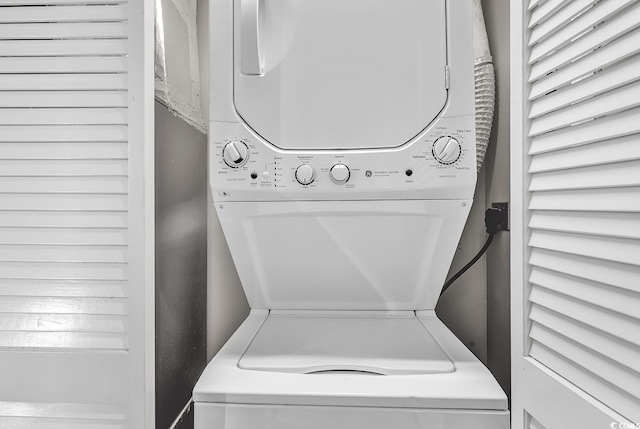 clothes washing area with laundry area and stacked washer and clothes dryer