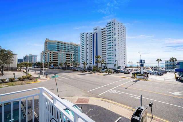 exterior space with a view of city, curbs, sidewalks, and street lights