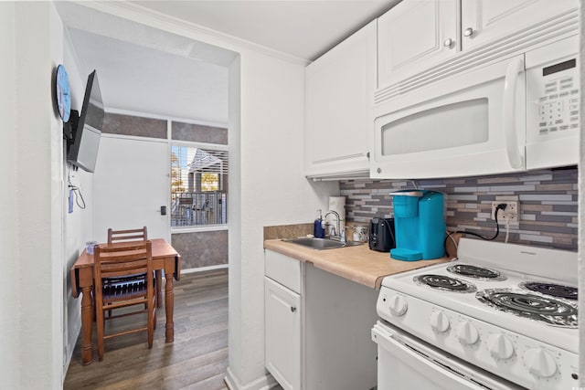 kitchen with white appliances, decorative backsplash, wood finished floors, white cabinetry, and a sink