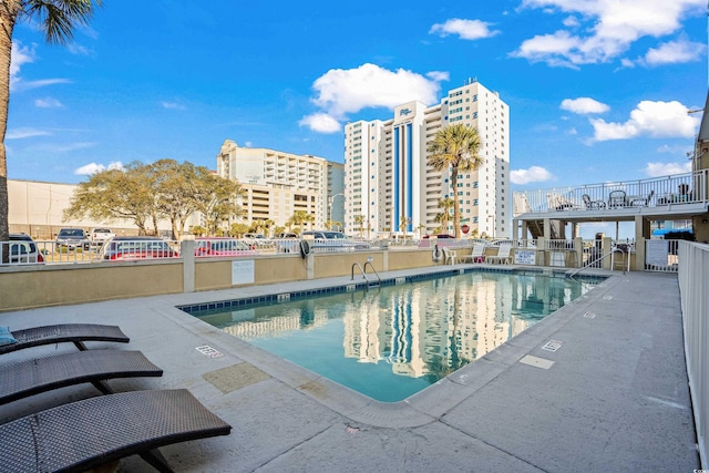 community pool featuring a view of city and a patio area