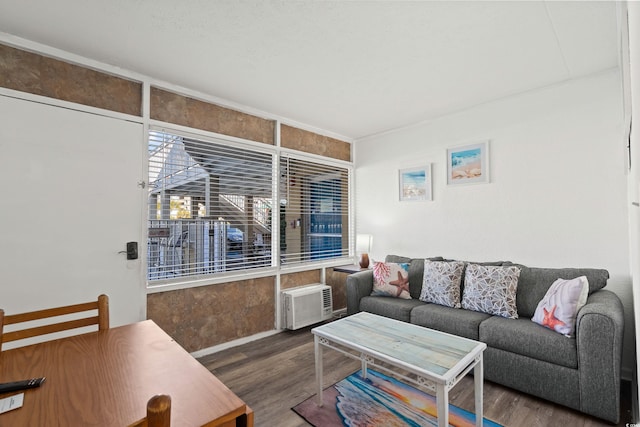 living room with a wall mounted AC and wood finished floors