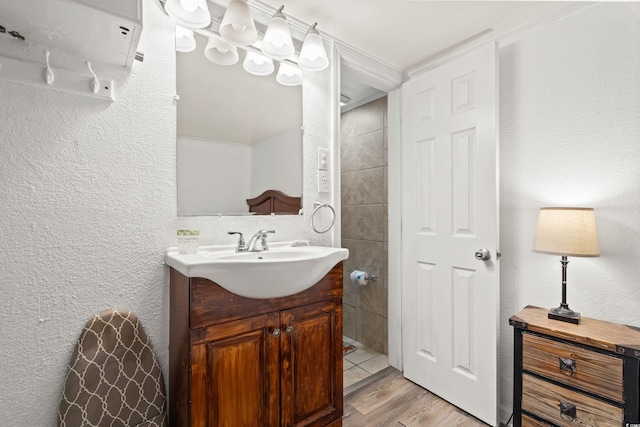 bathroom with a textured wall, vanity, and wood finished floors