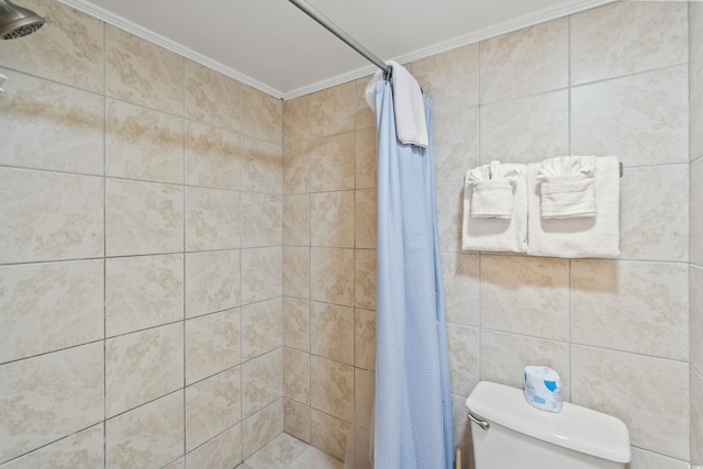 bathroom featuring toilet, ornamental molding, and tiled shower