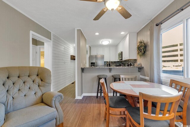 9501 Shore Dr Unit D-132, Myrtle Beach, SC 29572 - dining space with light wood-type flooring, ceiling fan, baseboards, and a textured ceiling