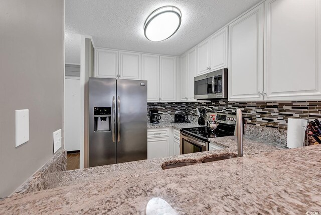 9501 Shore Dr Unit D-132, Myrtle Beach, SC 29572 - kitchen featuring appliances with stainless steel finishes, white cabinets, and light stone counters